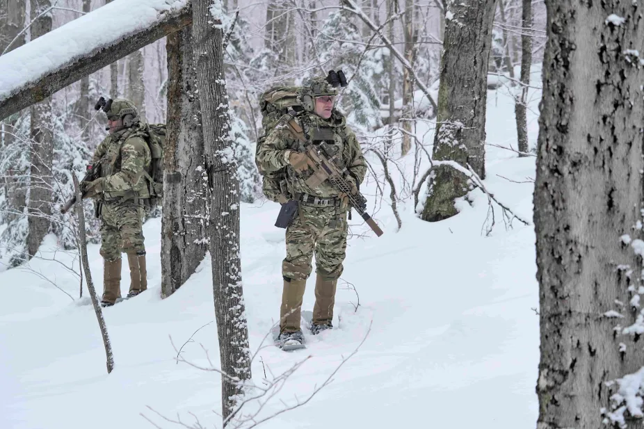 Man in military uniform standing in a snowy forest