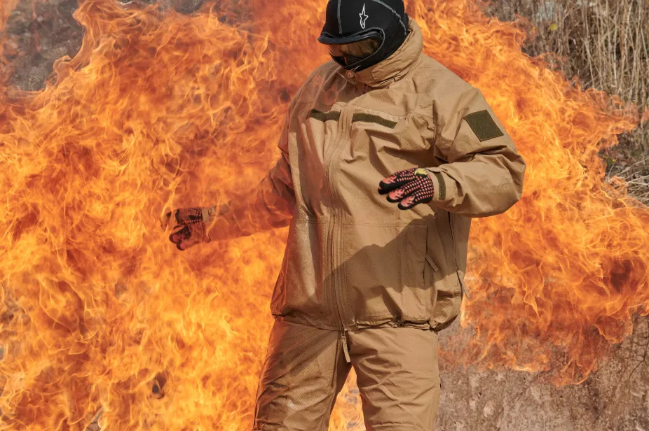 Man standing in and in front of large flame with protective GORE-TEX PYRAD® suit