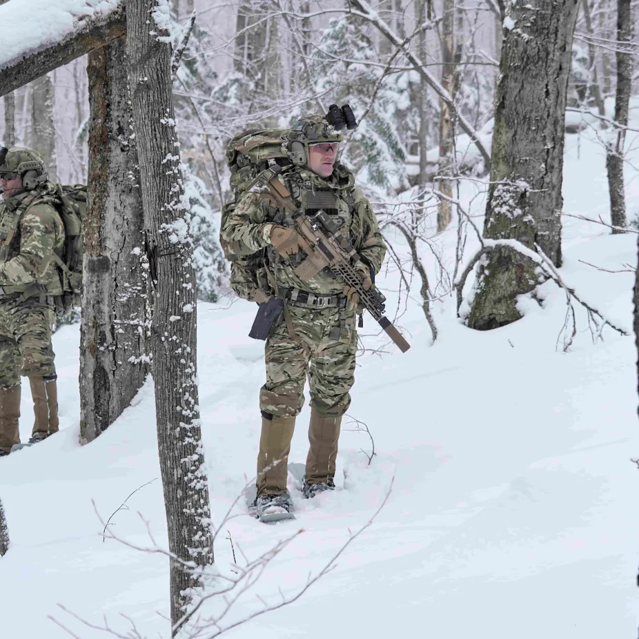 Man in military uniform standing in a snowy forest