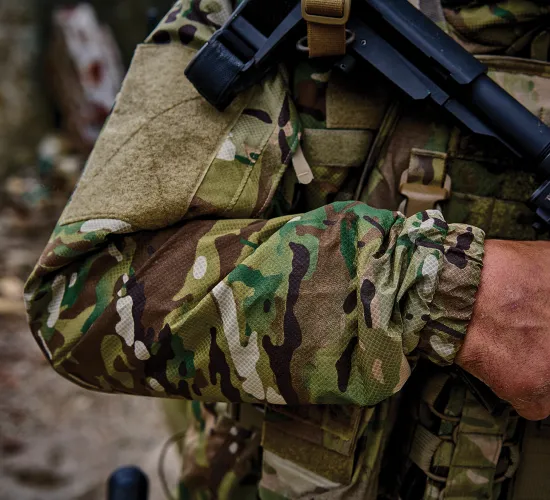 a close up of a defense personnel's arm holding a gun